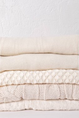 Soğuk hava için sıcak beyaz örgü giysiler yığını. Konforlu organik kazaklar. Hygge tarzı fikir