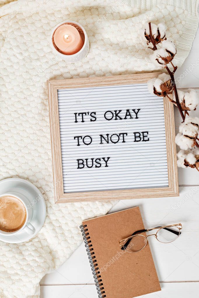 Letter board with text it's okay to not be busy. Comfort and cozy slow life concept. Flat lay, top view