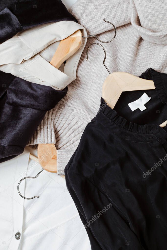 Flat lay of clothes and hangers assortment of women's clothing. Second hand sustainable shopping capsule minimal wardrobe slow fashion idea quality not quantity concept