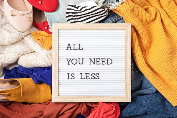 Быстрый модный фон с кучей дешевой, низкокачественной одежды. Одежда, сделанная в несправедливых, бесчеловечных условиях, идея. Воздействие на окружающую среду, концепция выбросов углерода