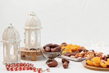 Ramazan Kareem ve iftar müslüman yemekleri, tatil konsepti. Cevizli tepsiler, kurutulmuş meyveler ve mumlu ikizler. Kutlama fikri
