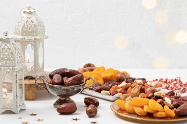 Ramazan Kareem ve iftar müslüman yemekleri, tatil konsepti. Cevizli tepsiler, kurutulmuş meyveler ve mumlu ikizler. Kutlama fikri