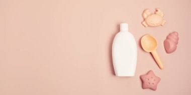 Çocuklar yaz aksesuarları ve güneşli günler ve tatiller için güneş kremi şişesi. Kumsalda eğlence için kum kalıpları ve güneş kremi.