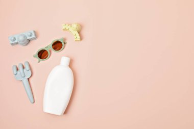 Çocuklar yaz aksesuarları ve güneşli günler ve tatiller için güneş kremi şişesi. Kumsalda eğlence için kum kalıpları ve güneş kremi.