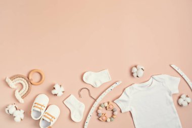 Çevre dostu bebek aksesuarlarıyla organik pamuktan yapılmış beyaz bebek tulumu. Marka, logo ve reklam için tulum şablonu. Düz yatış, üst görünüm