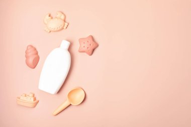 Çocuklar yaz aksesuarları ve güneşli günler ve tatiller için güneş kremi şişesi. Kumsalda eğlence için kum kalıpları ve güneş kremi.