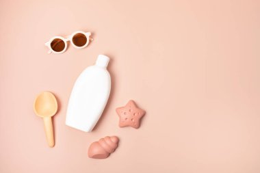 Çocuklar yaz aksesuarları ve güneşli günler ve tatiller için güneş kremi şişesi. Güneş gözlükleri, sandaletler, kumsal eğlencesi için kum kalıpları. 