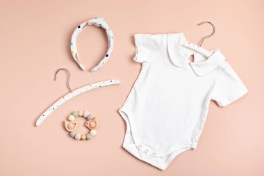 Çevre dostu bebek aksesuarlarıyla organik pamuktan yapılmış beyaz bebek tulumu. Marka, logo ve reklam için tulum şablonu. Düz yatış, üst görünüm