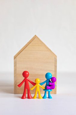 Ahşap evin önündeki mutlu bebek ailesi. Aile evi, sigorta ve gayrimenkul yatırımı konsepti