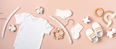 Çevre dostu bebek aksesuarlarıyla organik pamuktan yapılmış beyaz bebek tulumu. Marka, logo ve reklam için tulum şablonu. Düz yatış, üst görünüm