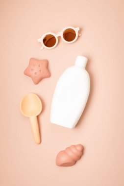 Çocuklar yaz aksesuarları ve güneşli günler ve tatiller için güneş kremi şişesi. Güneş gözlükleri, sandaletler, kumsal eğlencesi için kum kalıpları. 