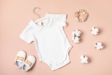 Çevre dostu bebek aksesuarlarıyla organik pamuktan yapılmış beyaz bebek tulumu. Marka, logo ve reklam için tulum şablonu. Düz yatış, üst görünüm