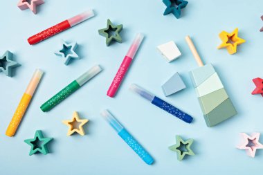 Mavi arka planda keçeli kalem ve çocuk oyuncakları vardı. Yaratıcı ve gelişimsel faaliyetler. Üst manzara, düz uzanma