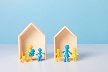 Sığınak arayan Ukraynalı aileler kavramı. Ahşap evlerin önündeki sarı ve mavi bebekler. Güvenli bir yer arayan savaş terörü mağdurları. Sivillerin ve Ukraynalı ailelerin tahliyesi