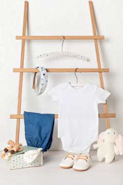 Çevre dostu bebek aksesuarlarıyla organik pamuktan yapılmış beyaz bebek tulumu. Marka, logo ve reklam için tulum şablonu. Düz yatış, üst görünüm