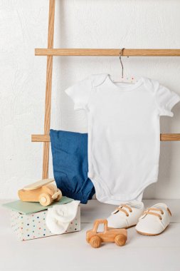 Çevre dostu bebek aksesuarlarıyla organik pamuktan yapılmış beyaz bebek tulumu. Marka, logo ve reklam için tulum şablonu. Düz yatış, üst görünüm