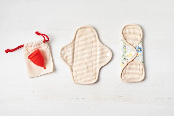 Zero waste periods kit. Eco friendly feminine hygiene, reuse concept. Reusable sanitary pads and menstrual cup for personal hygiene. Waste-free lifestyle.
