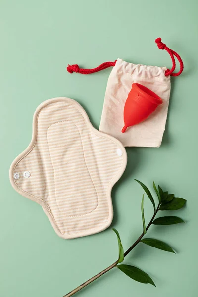 Zero waste periods kit. Eco friendly feminine hygiene, reuse concept. Reusable sanitary pads and menstrual cup for personal hygiene. Waste-free lifestyle.