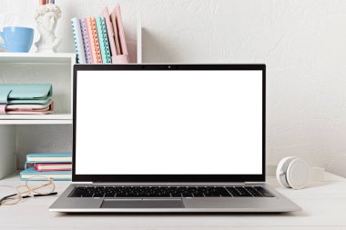 Boş dizüstü bilgisayar, masa başı rafları ve ofis malzemeleri olan masaüstü düzenleyici. Okula, ev ofisine, öğrenim konseptine geri dönmek. Model, şablon