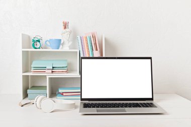 Boş dizüstü bilgisayar, masa başı rafları ve ofis malzemeleri olan masaüstü düzenleyici. Okula, ev ofisine, öğrenim konseptine geri dönmek. Model, şablon