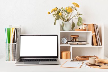 Empty laptop screen, desktop organizer with desk shelves and office supplies. Back to school, home office, begining of studies concept. Mockup, template