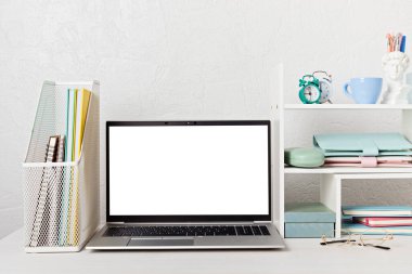 Boş dizüstü bilgisayar, masa başı rafları ve ofis malzemeleri olan masaüstü düzenleyici. Okula, ev ofisine, öğrenim konseptine geri dönmek. Model, şablon