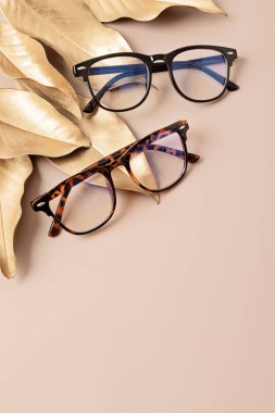 Pastel arka plan üzerinde şık gözlükler. Optik mağaza, gözlük seçimi, göz testi, göz doktorunda vizyon muayenesi moda aksesuarları konsepti. Üst manzara, düz uzanma