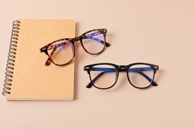 Pastel arka plan üzerinde şık gözlükler. Optik mağaza, gözlük seçimi, göz testi, göz doktorunda vizyon muayenesi moda aksesuarları konsepti. Üst manzara, düz uzanma