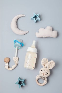Flat lay with baby sleep accessories with milk bottles, pacifier and toys. Newborn sleeping rules concept