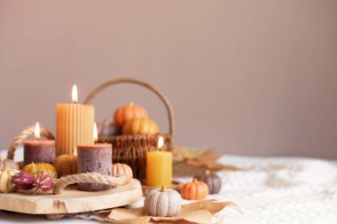 Sonbahar masa dekorasyonu. El yapımı balkabakları ve mumlarla sonbahar tatili için iç dekorasyon. Tatil tebrik kartı.