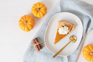 Kabaklı, fındıklı, mevsimlik baharatlı ve bir dilim turtalı balkabağı turtası. Şükran Günü ve sonbahar tatilleri kutlama konsepti. Üst görünüm, düz görünüm