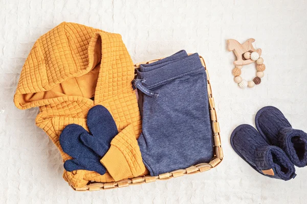 Collection of cute organic baby clothes, booties, toys. Warm outfit for cold weather. Newborn gifts for cristmas and baby shower, second hand clothes, donation idea.