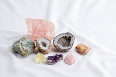 Kumaş arka planında Reiki çakra kristallerini iyileştirmek. Refah, uyum, meditasyon, rahatlama, metafizik ve ruhani uygulamalar için taşıyıcılar. Enerji güç kavramı