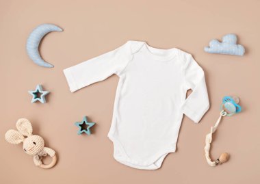 Flat lay with baby sleep accessories with pacifier, pajamas and toys. Newborn sleeping rules concept. Onesie mockup