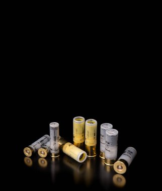 Karanlık bir yüzeyde yansımalı pompalı tüfek fişekleri. Siyah arka planda düz namlulu silahlar için mühimmat..