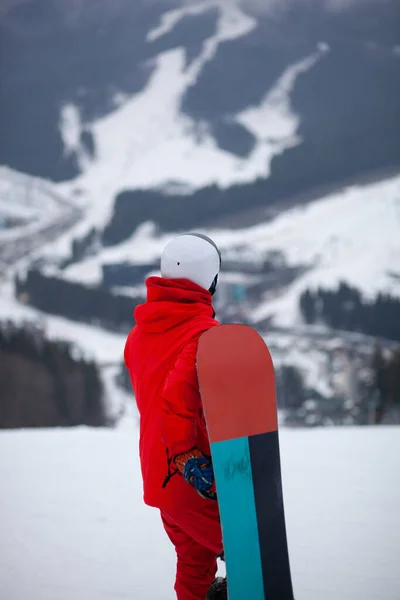 Mężczyzna Czerwonej Kurtce Stojakiem Snowboardowym Zboczu Góry — Zdjęcie stockowe