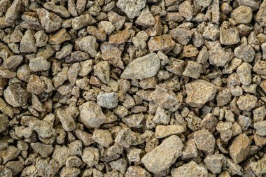 Küçük kabuklu kaya dokusu. Küçük kaldırım taşlarının ve kaya parçalarının arka planı. Kahverengi taşlar.