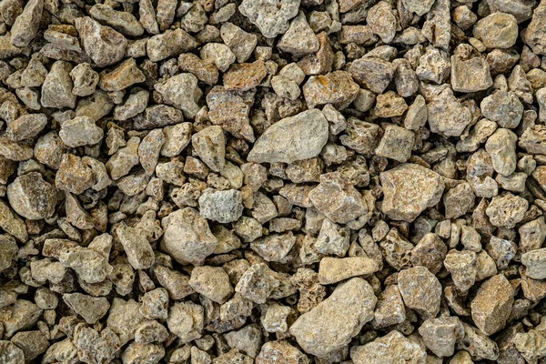 Küçük kabuklu kaya dokusu. Küçük kaldırım taşlarının ve kaya parçalarının arka planı. Kahverengi taşlar.