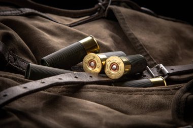 Pompalı mermiler yakın plan. Sırt çantasındaki haki rengi bez üzerinde yumuşak delikli silahlar için mühimmat. Koyu arkaplan.