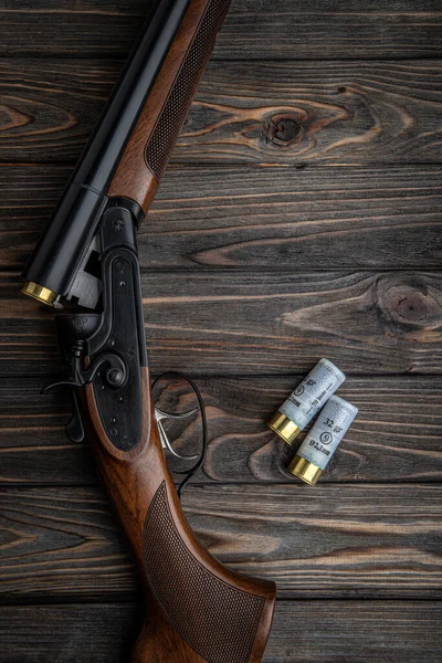 木製のテーブルの上にダブルバレル狩猟ライフルを開いた ショットガン弾だ 暗褐色の木の背景 — ストック写真