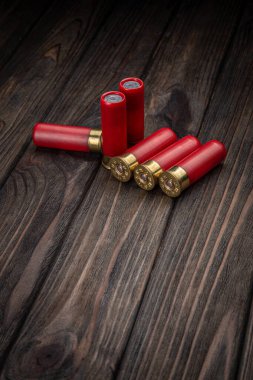 Kahverengi ahşap bir masada pompalı tüfek fişekleri. 12 kalibrelik pürüzsüz silahlar için mühimmat. Av mühimmatı.