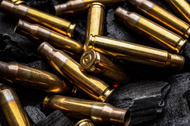 Silahlardan çıkan boş mermiler için yanan siyah kömürler. Savaşın sonuçları işte. Koyu arkaplan.