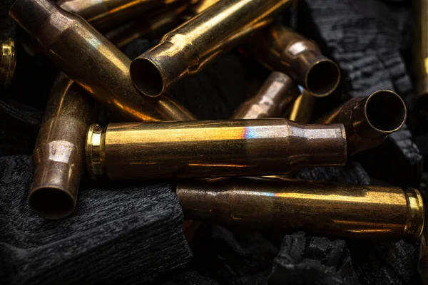 Silahlardan çıkan boş mermiler için yanan siyah kömürler. Savaşın sonuçları işte. Koyu arkaplan.