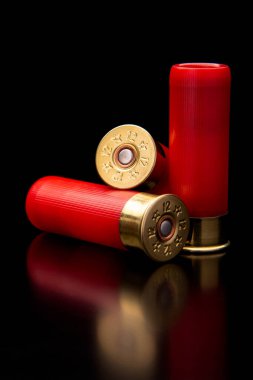 Siyah yansıtıcı yüzeyde av tüfeği mermileri. 12 kalibrelik pürüzsüz silahlar için mühimmat. Cephanelik avlıyorum. Koyu arkaplan.