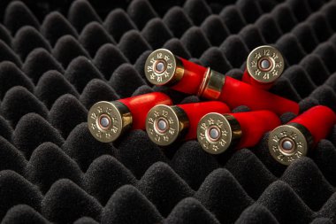 Köpük kauçuk üzerinde av tüfeği mermisi. 12 kalibrelik pürüzsüz silahlar için mühimmat. Cephanelik avlıyorum. Koyu arkaplan.