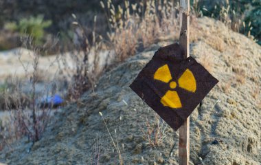 Paslı metal bir plakada radyasyon işareti. Tehlike uyarısı. Kıyamet sonrası işareti..