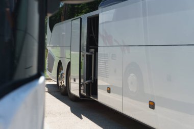 Otobüs durağında insanları taşımak için modern otobüsler duruyor. Açık otobüs kapısına yakın çekim. Hafif arkaplan.