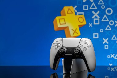 May 2, 2020, Odessa, Ukraine. White new Playstation 5 gamepad with Playstation Plus on screen, selective focus. Blue background.