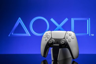 2 Mayıs 2020, Odessa, Ukrayna. Ekranda Playstation sembolleri olan beyaz yeni Playstation 5 oyun platformu, seçici odak. Mavi arkaplan.