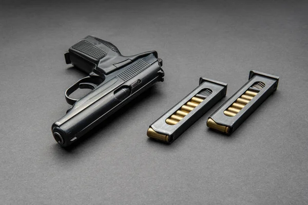 手枪和弹药筒在黑暗的背景 一种用于自卫的短管武器 — 图库照片